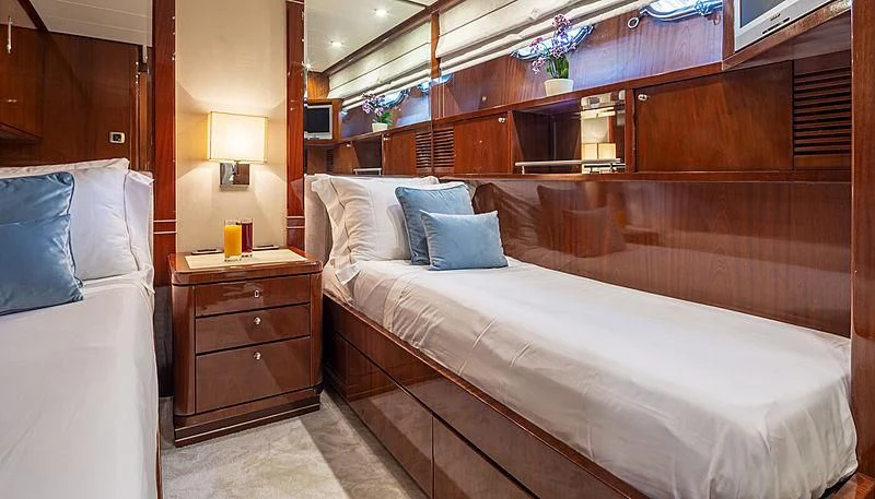 a bed with a white bed spread aboard GRACE Yacht for Sale