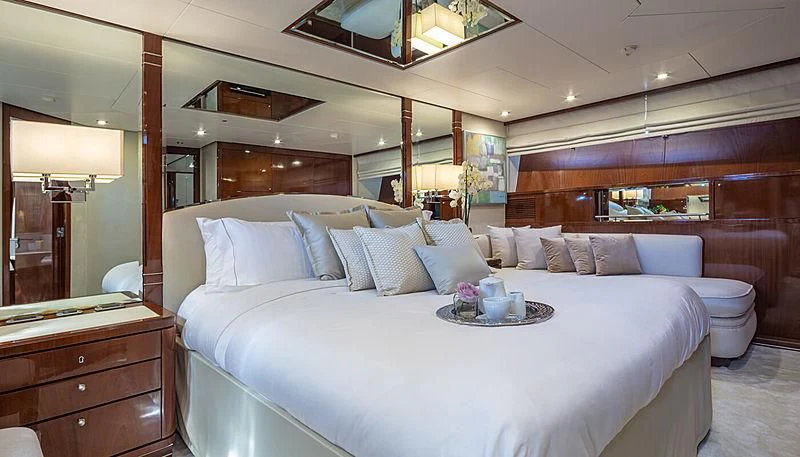 a bed with a white bed spread aboard GRACE Yacht for Sale
