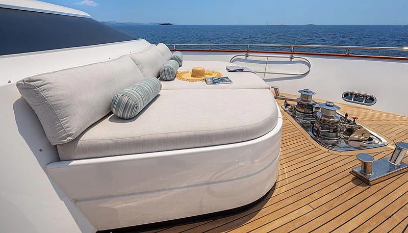 a white bed on a wooden deck aboard GRACE Yacht for Sale