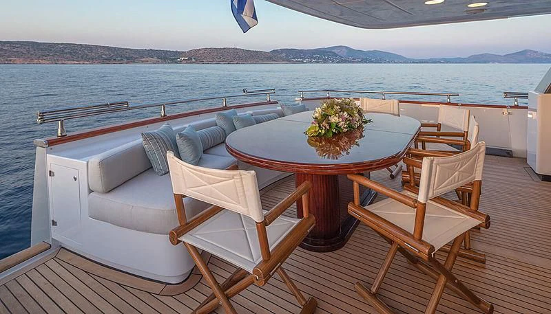 a table and chairs on a deck overlooking a body of water aboard GRACE Yacht for Sale