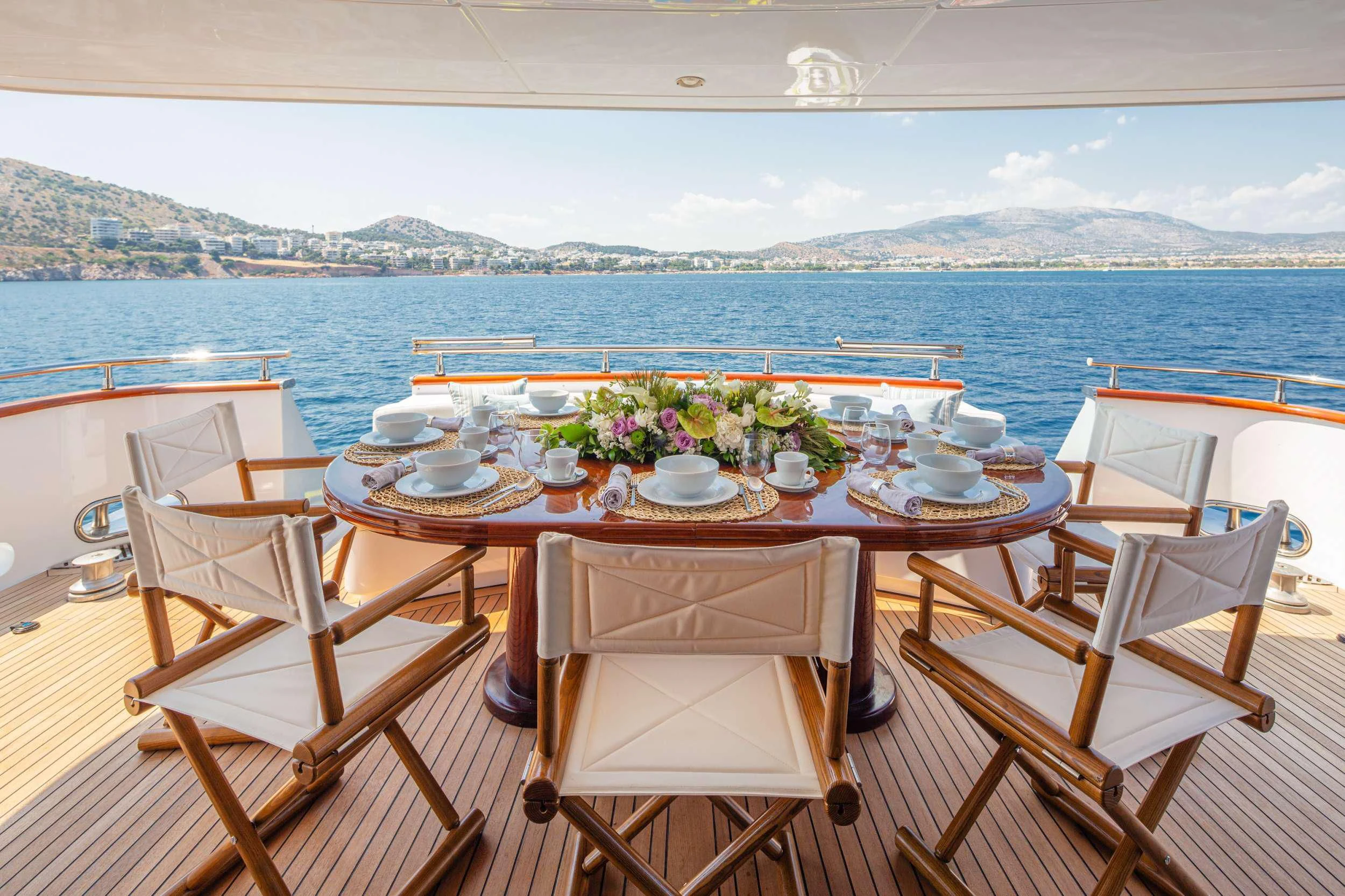 a table set for a meal on a balcony overlooking the ocean aboard GRACE Yacht for Sale