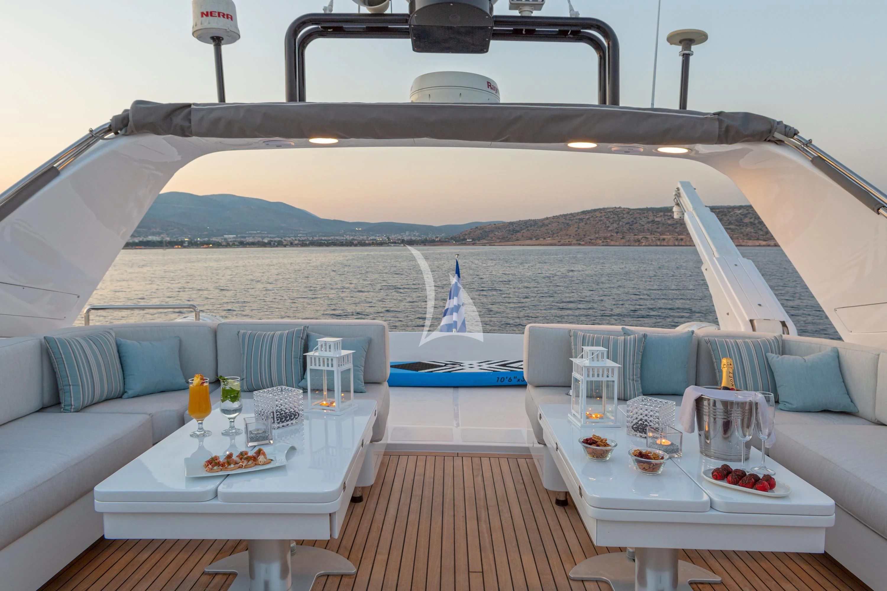 a large white boat with blue pillows and a table with food on it aboard GRACE Yacht for Sale