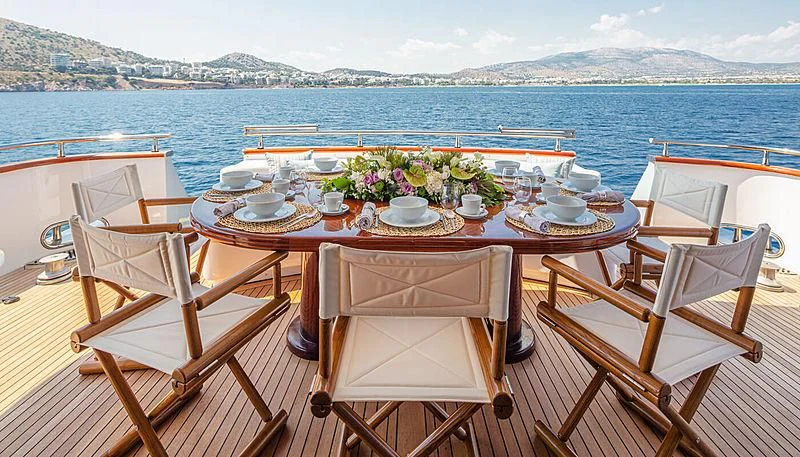 a table set with chairs and a view of the ocean aboard GRACE Yacht for Sale