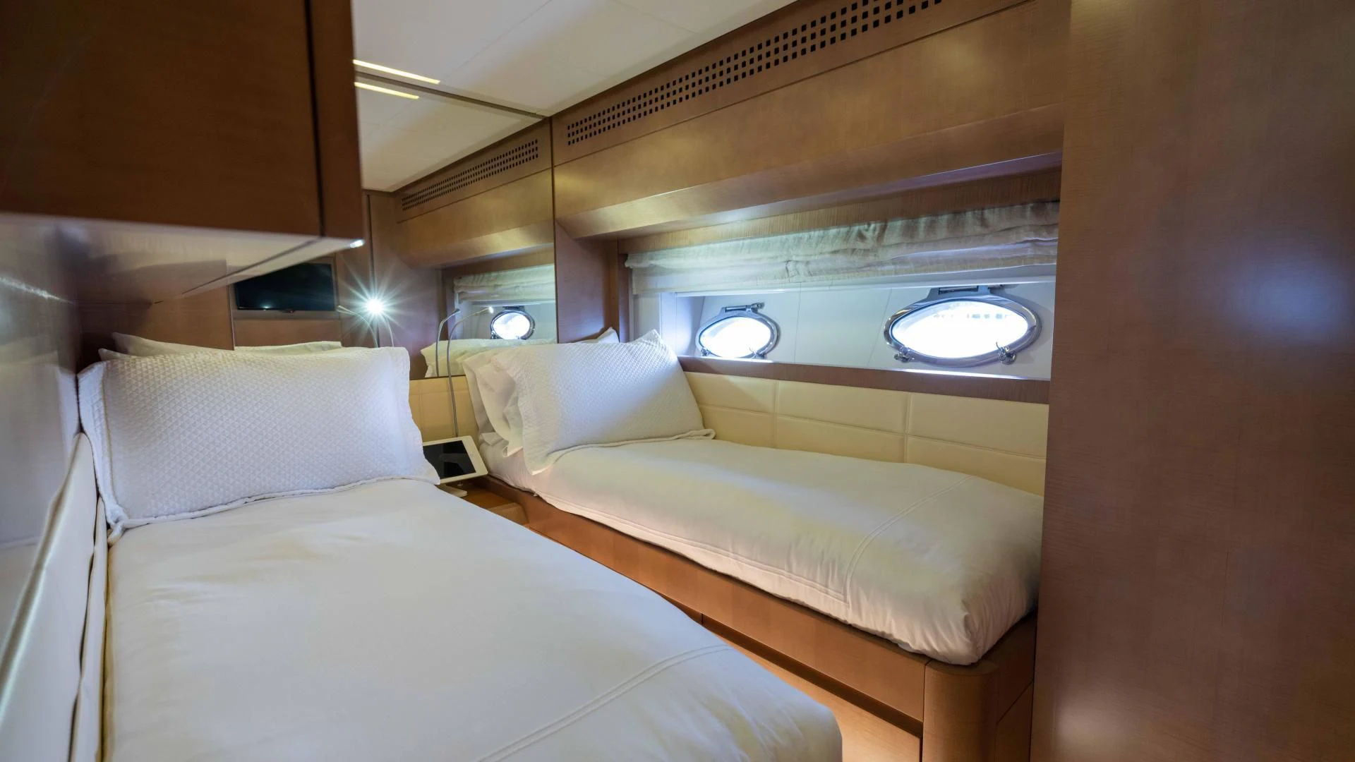 a room with beds and a round mirror aboard VIXEN Yacht for Sale