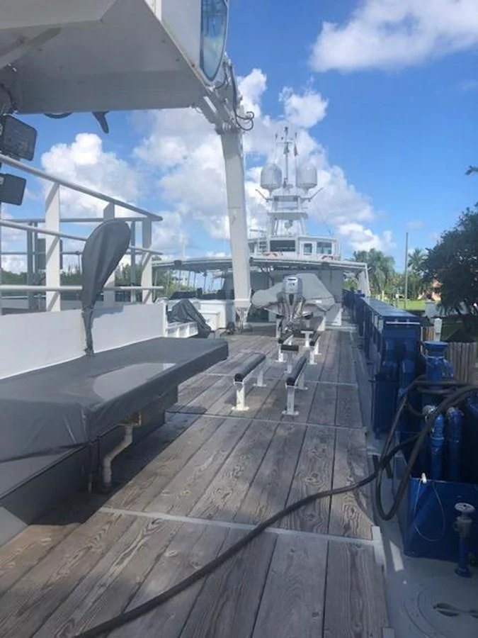 a deck with a large ship in the background aboard OCEANUS V Yacht for Sale