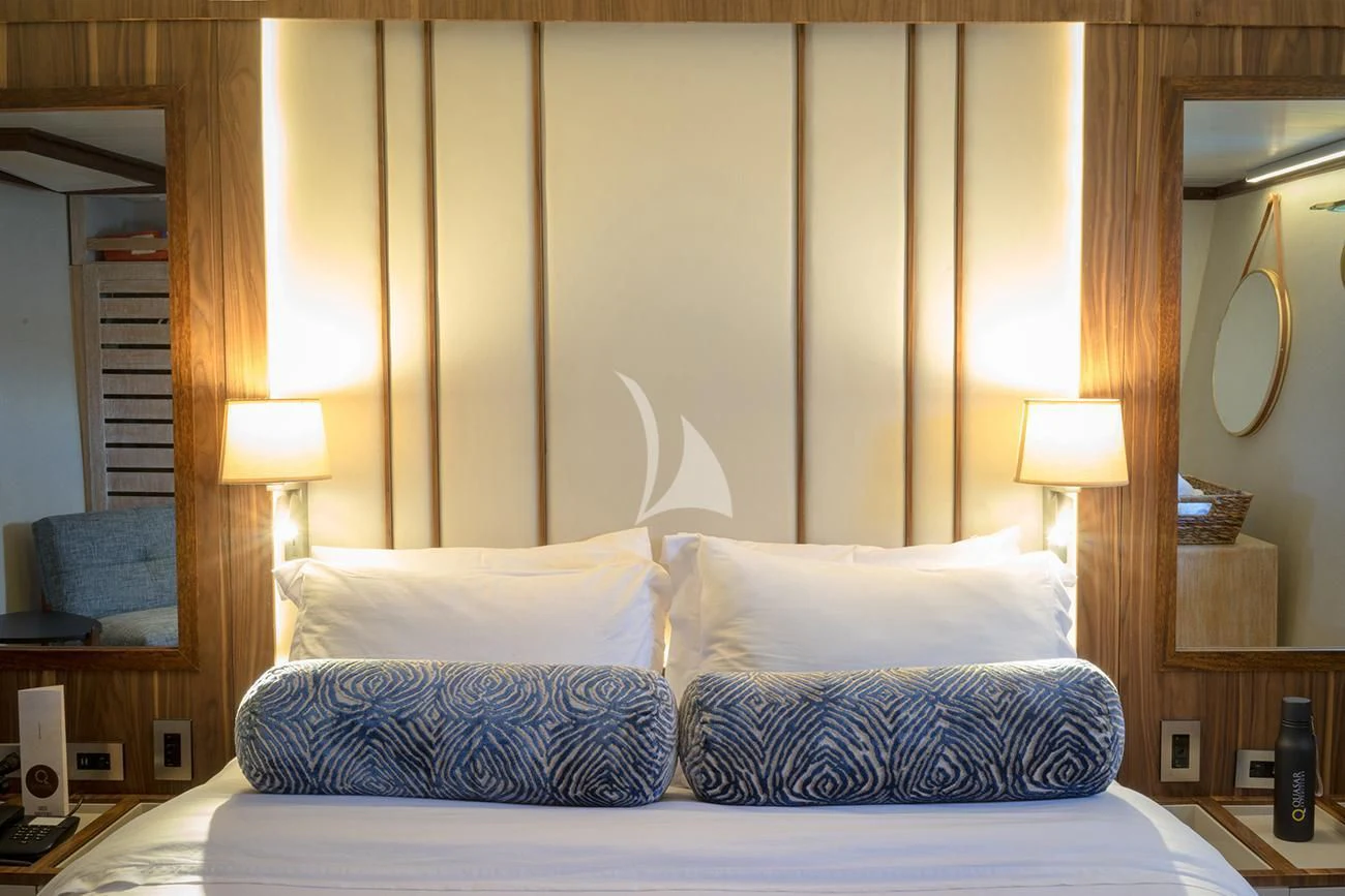 a bed with blue and white pillows aboard EVOLUTION Yacht for Sale