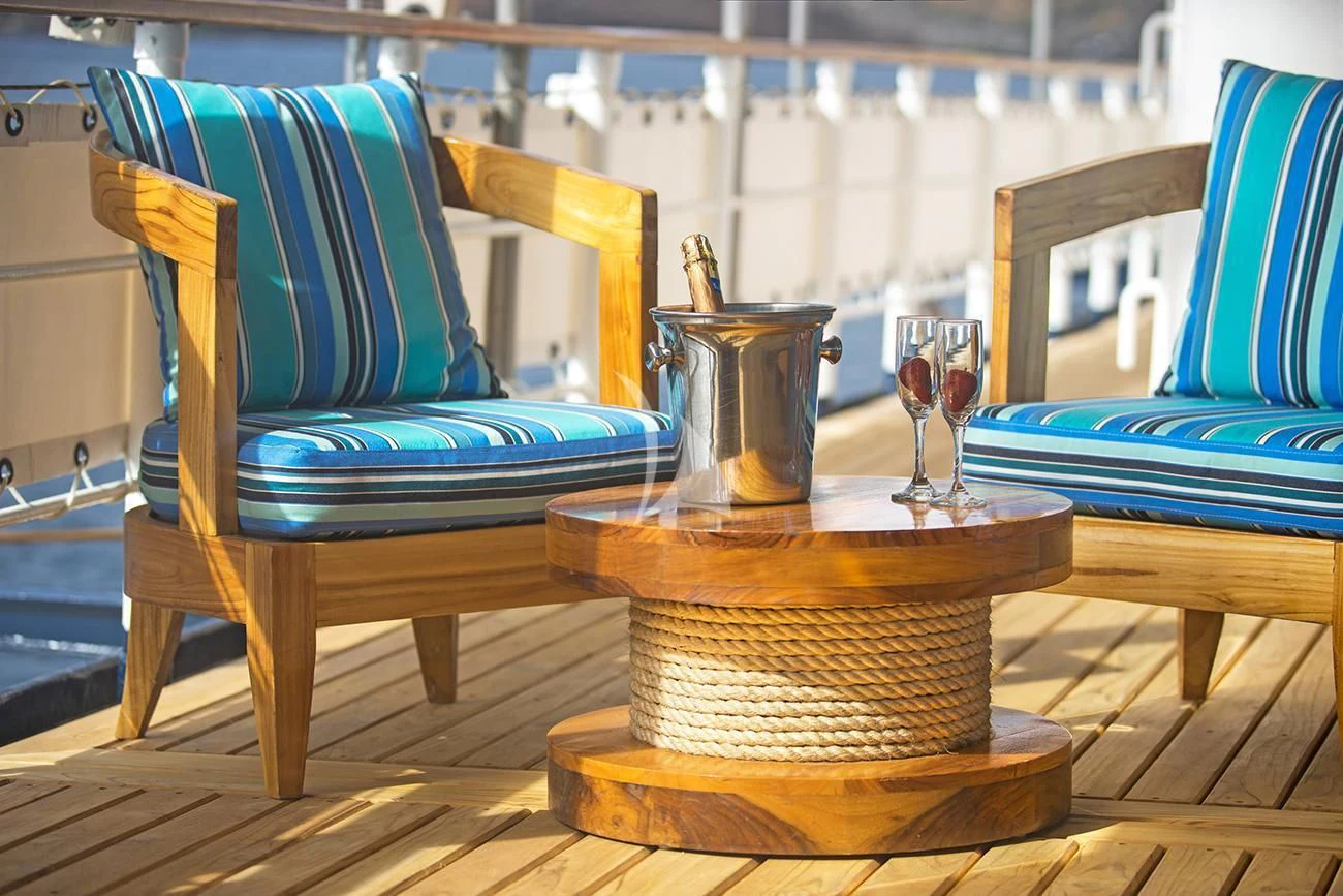 a table with chairs and a glass on it aboard EVOLUTION Yacht for Sale