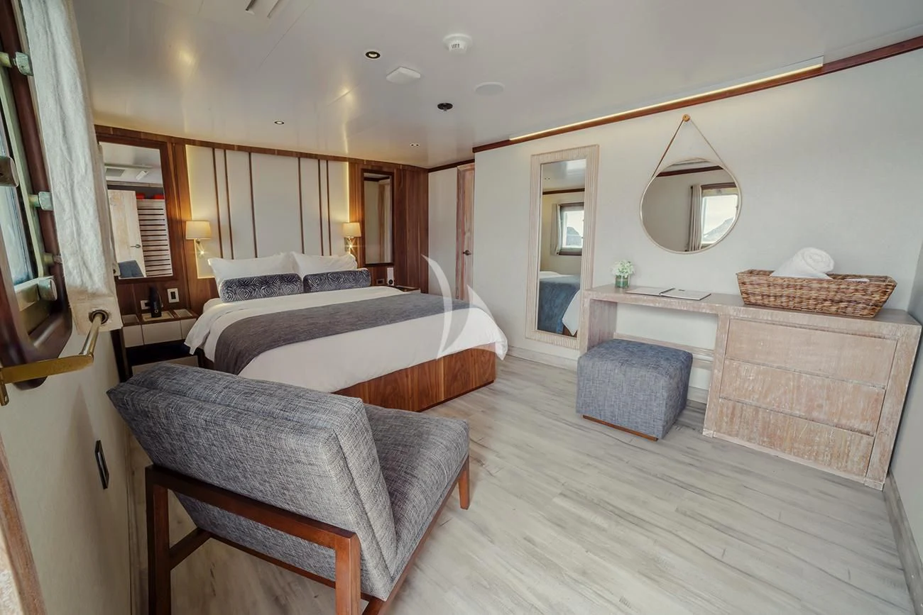 a bedroom with a bed and a mirror aboard EVOLUTION Yacht for Sale