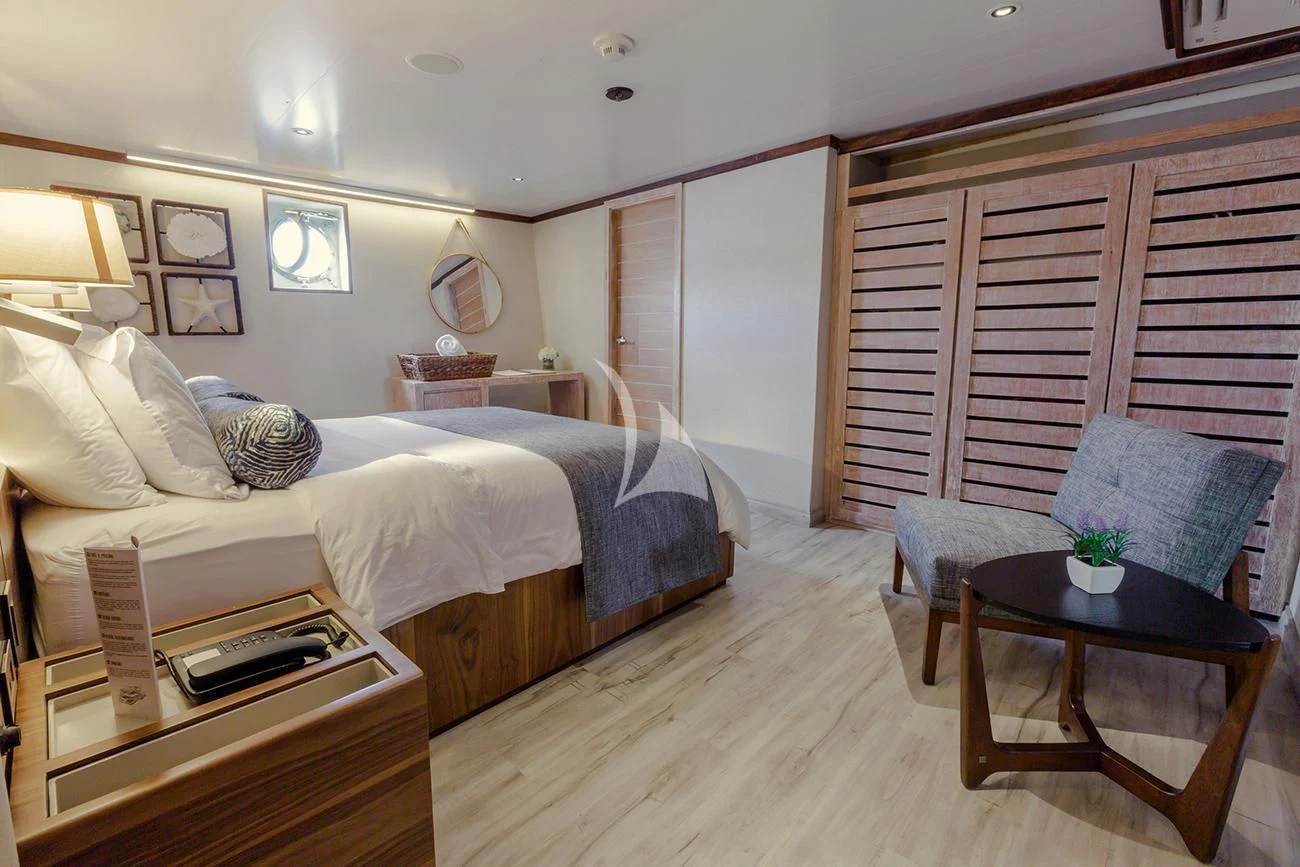 a bedroom with a bed and a table aboard EVOLUTION Yacht for Sale