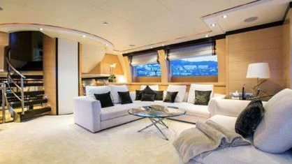 a living room with a large white couch and a large window aboard LIBERDADE Yacht for Sale