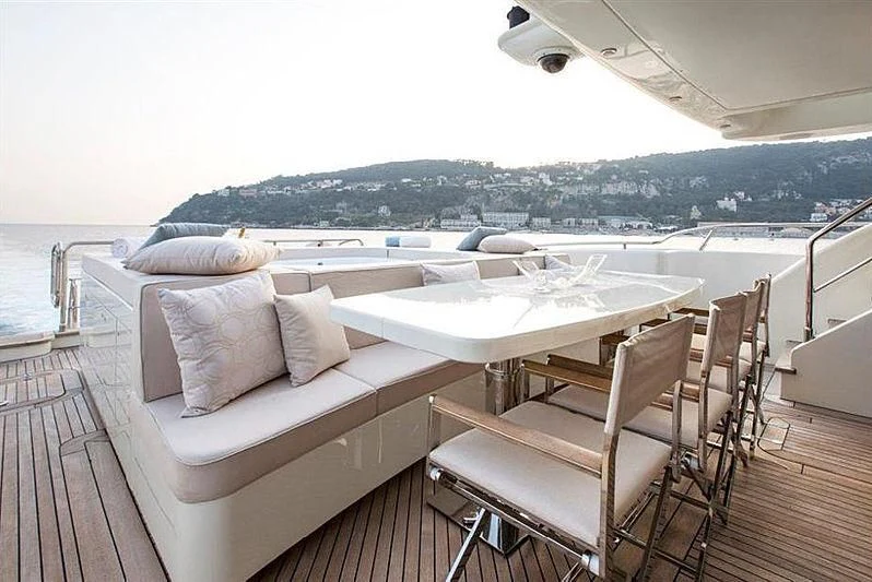 a deck with a table and chairs on it aboard LIBERDADE Yacht for Sale