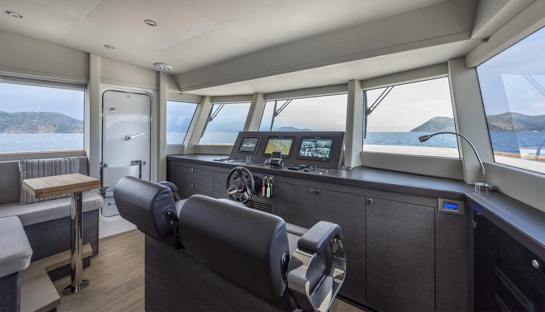 inside of a vehicle with a desk and chairs and a window aboard NUMARINE 26XP/24 Yacht for Sale