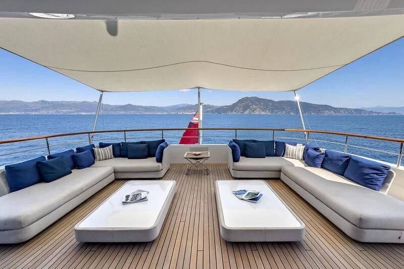 a large white lounge chair with a table and a white table on a boat in the water aboard GO Yacht for Sale
