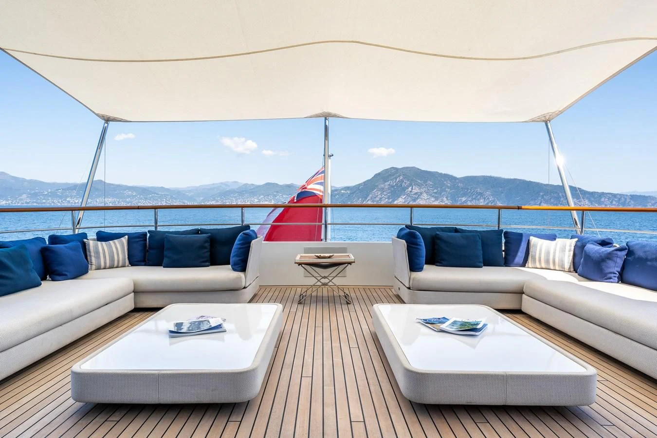a large white tent with a red sailboat on the water aboard GO Yacht for Sale
