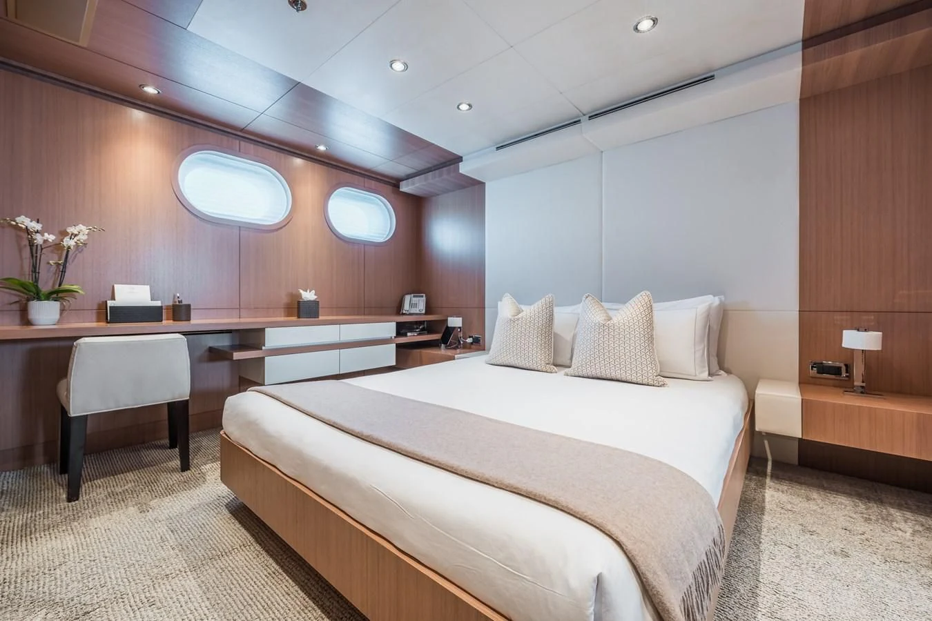 a room with a bed and desk aboard GO Yacht for Sale