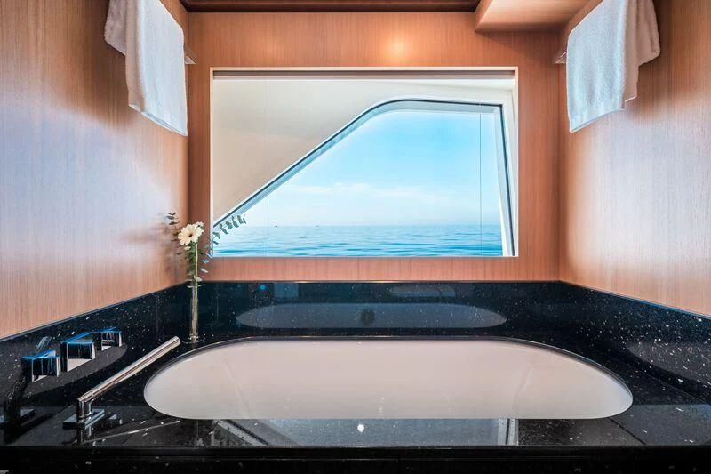 a bathroom with a large round mirror aboard GO Yacht for Sale