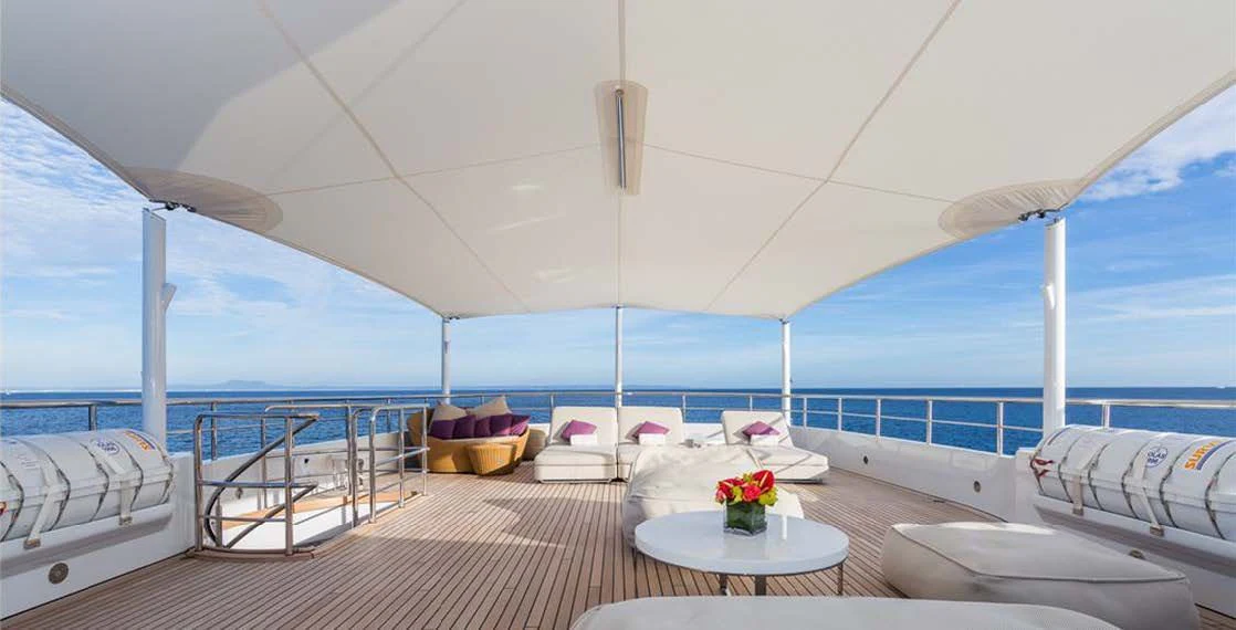 a balcony with a table and chairs aboard GO Yacht for Sale