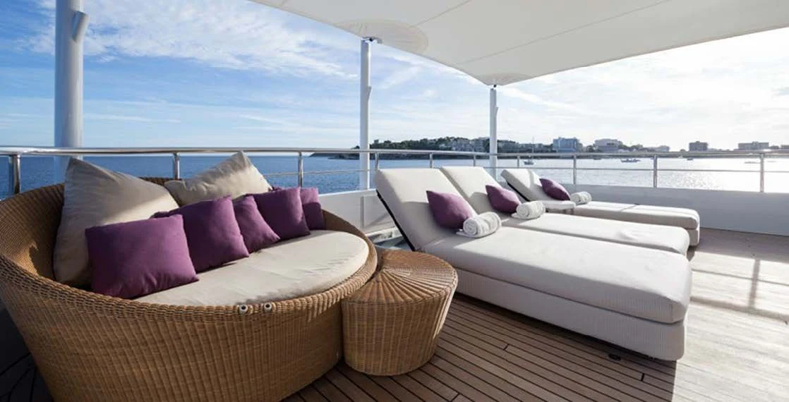 a large white bed with purple pillows aboard GO Yacht for Sale