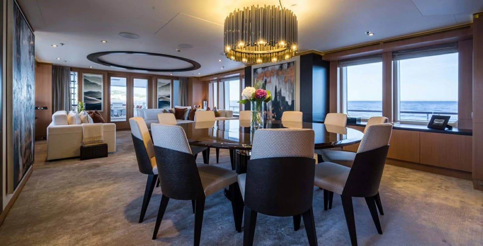 a large room with chairs and a table and a couch aboard GO Yacht for Sale