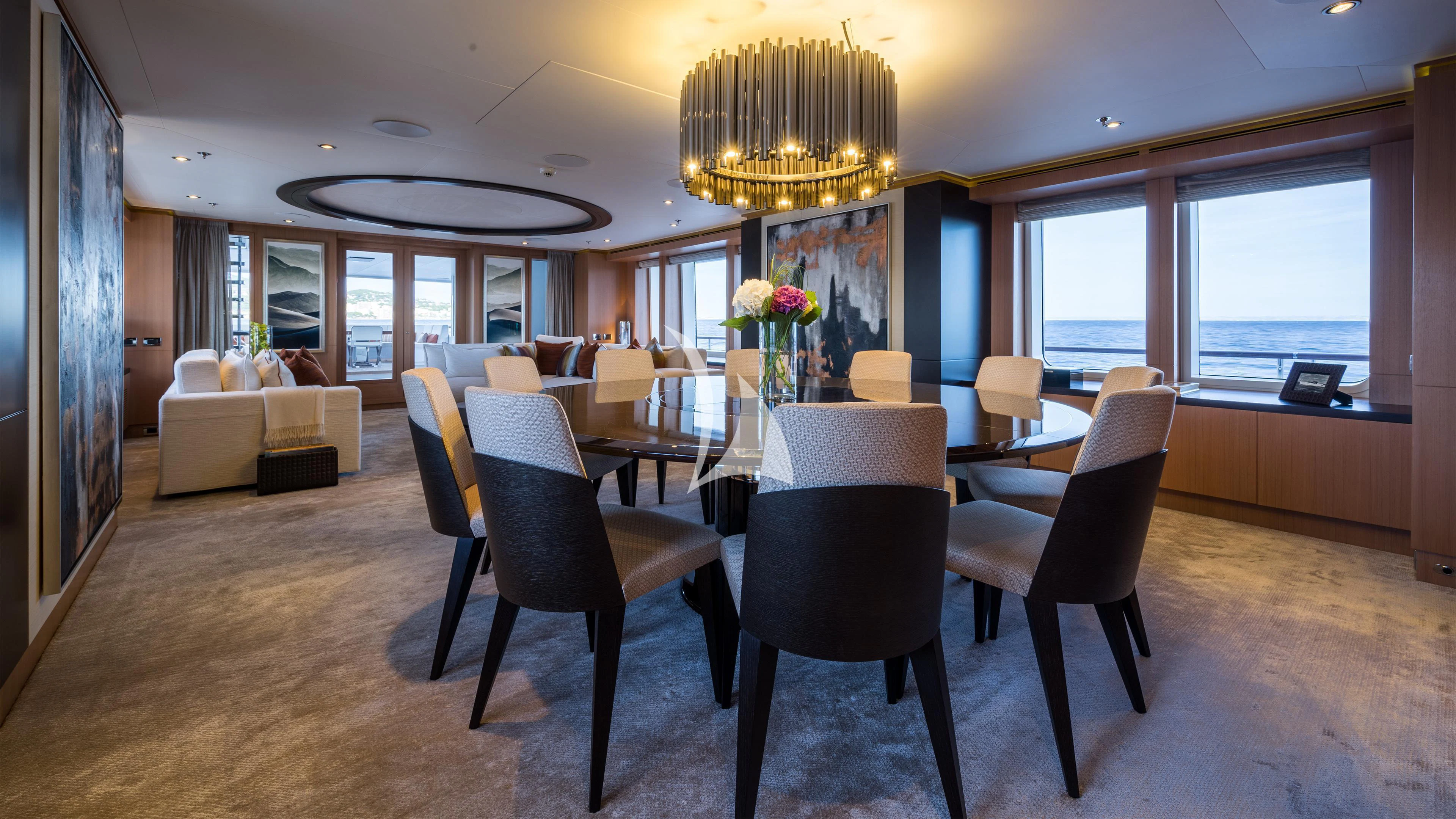 a large room with chairs and a chandelier aboard GO Yacht for Sale