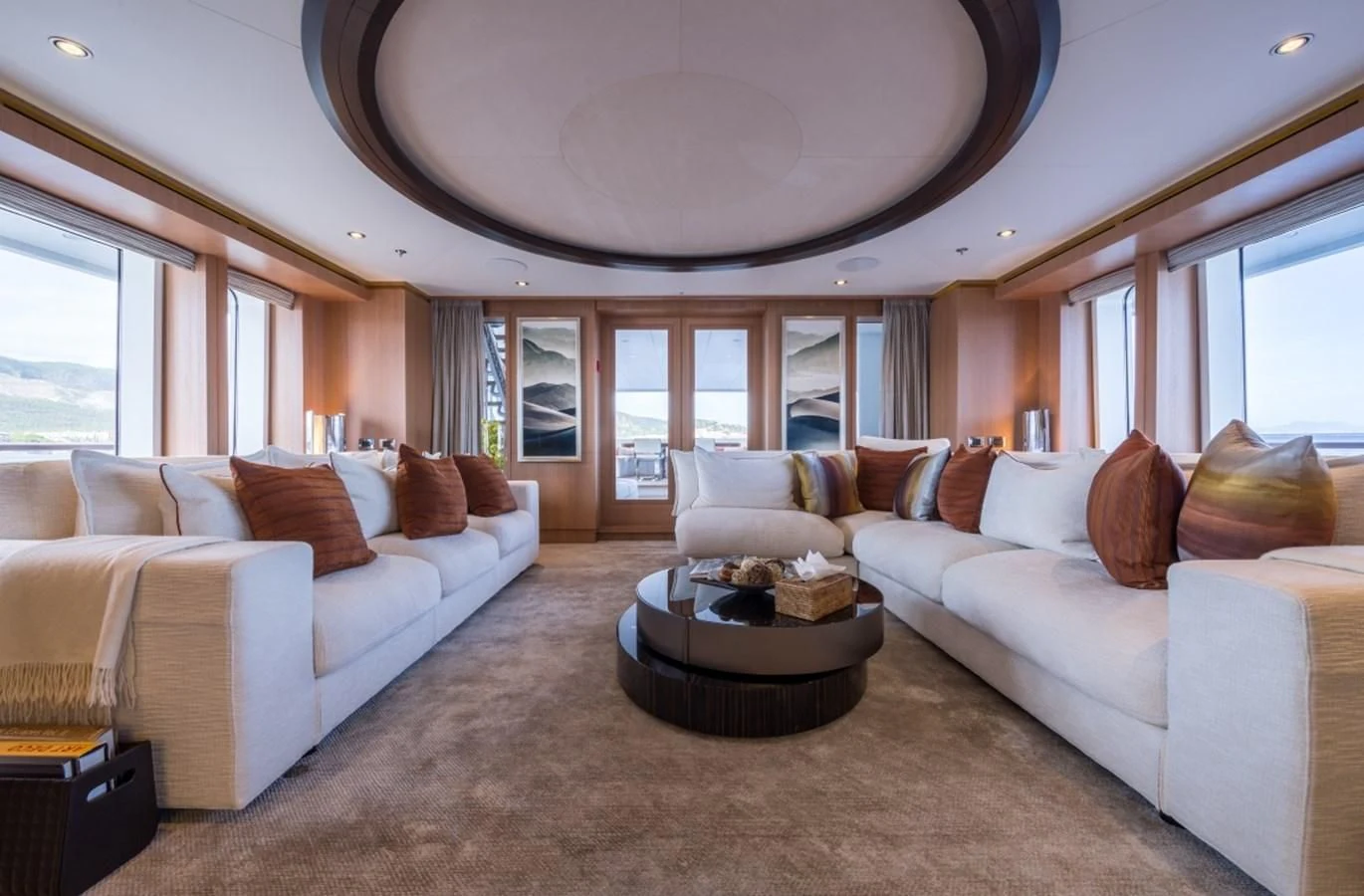 a living room with a large white couch and a large window aboard GO Yacht for Sale