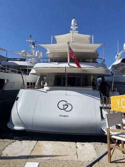 a white boat with a flag on it aboard GO Yacht for Sale