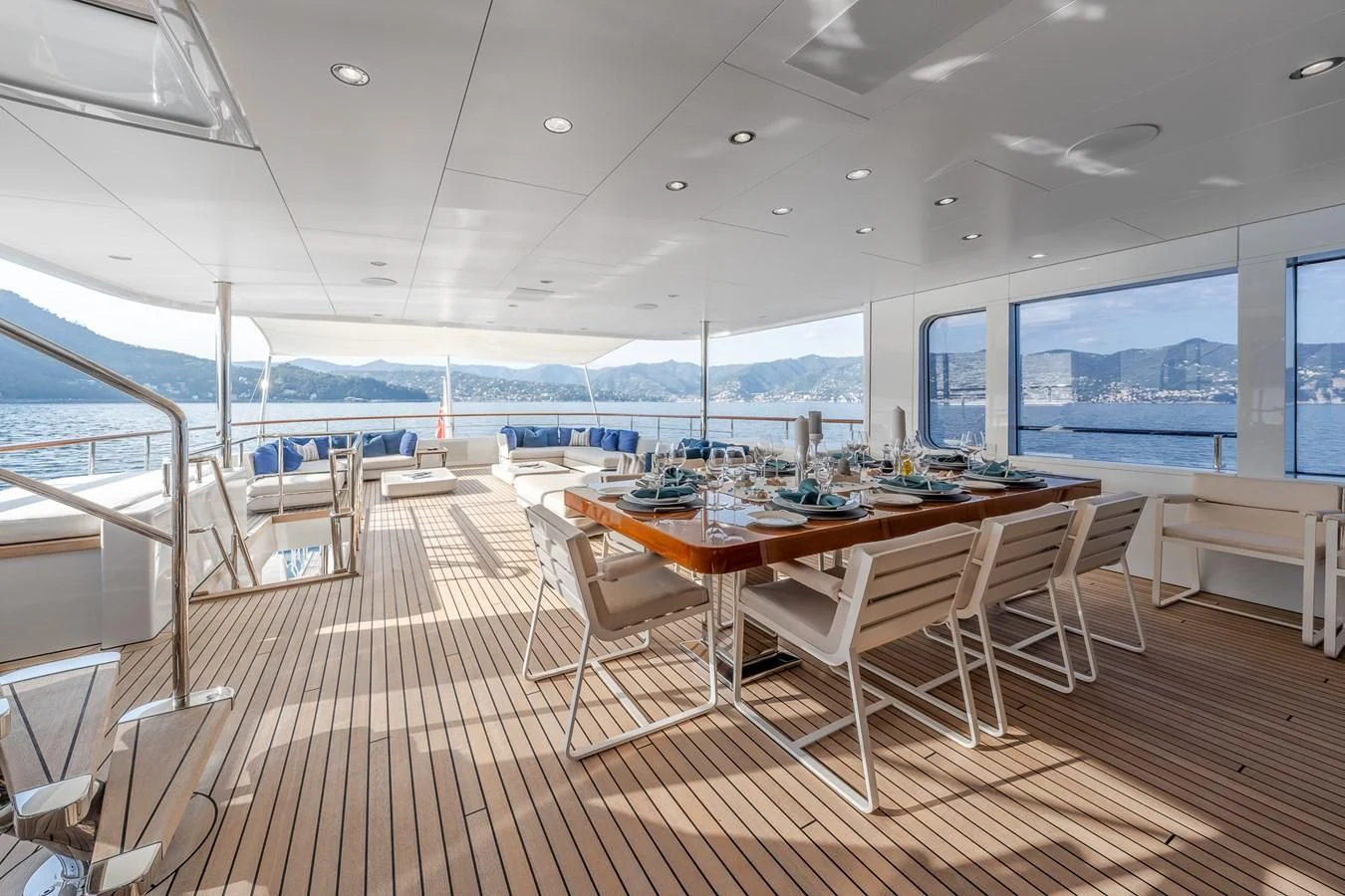 a large room with a table and chairs and a large body of water aboard GO Yacht for Sale