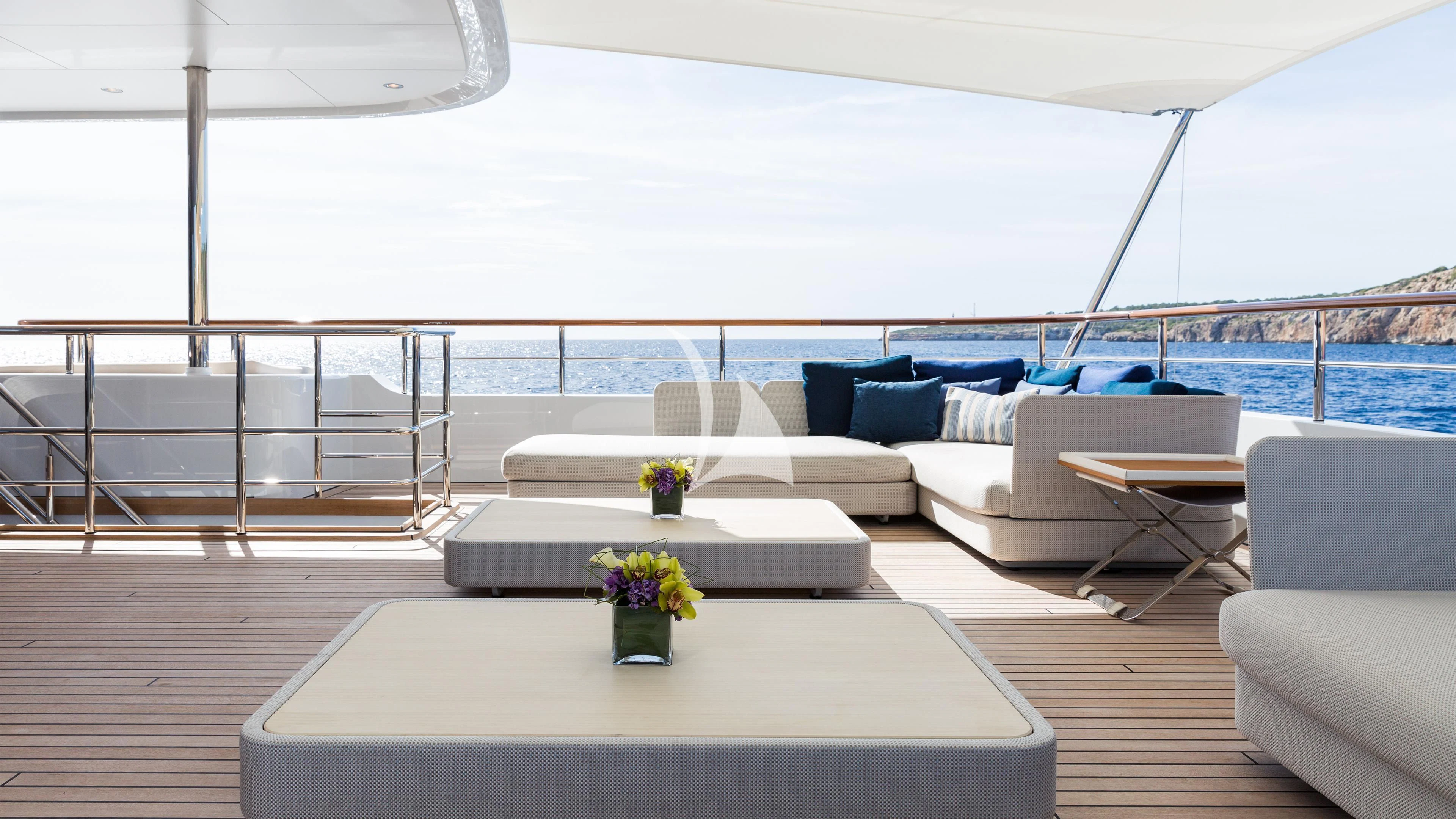 a living room with a large white sofa and a table with flowers on it aboard GO Yacht for Sale
