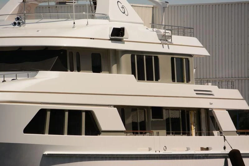 a white boat with a black and white stripe aboard GO Yacht for Sale