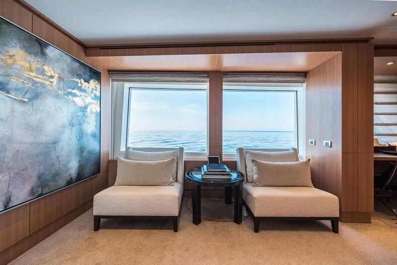 a room with a couch and a table and a window aboard GO Yacht for Sale
