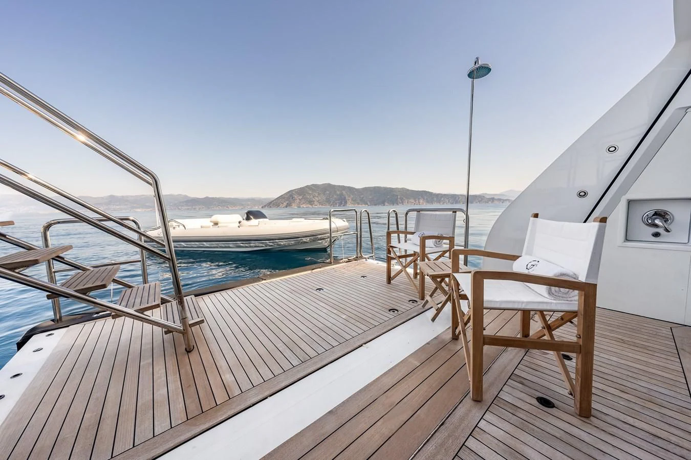 a deck with chairs and tables on it aboard GO Yacht for Sale