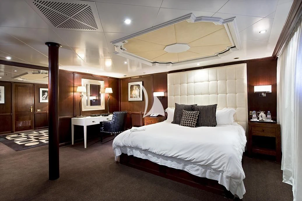 a bedroom with a bed and a chair aboard FORCE BLUE Yacht for Charter