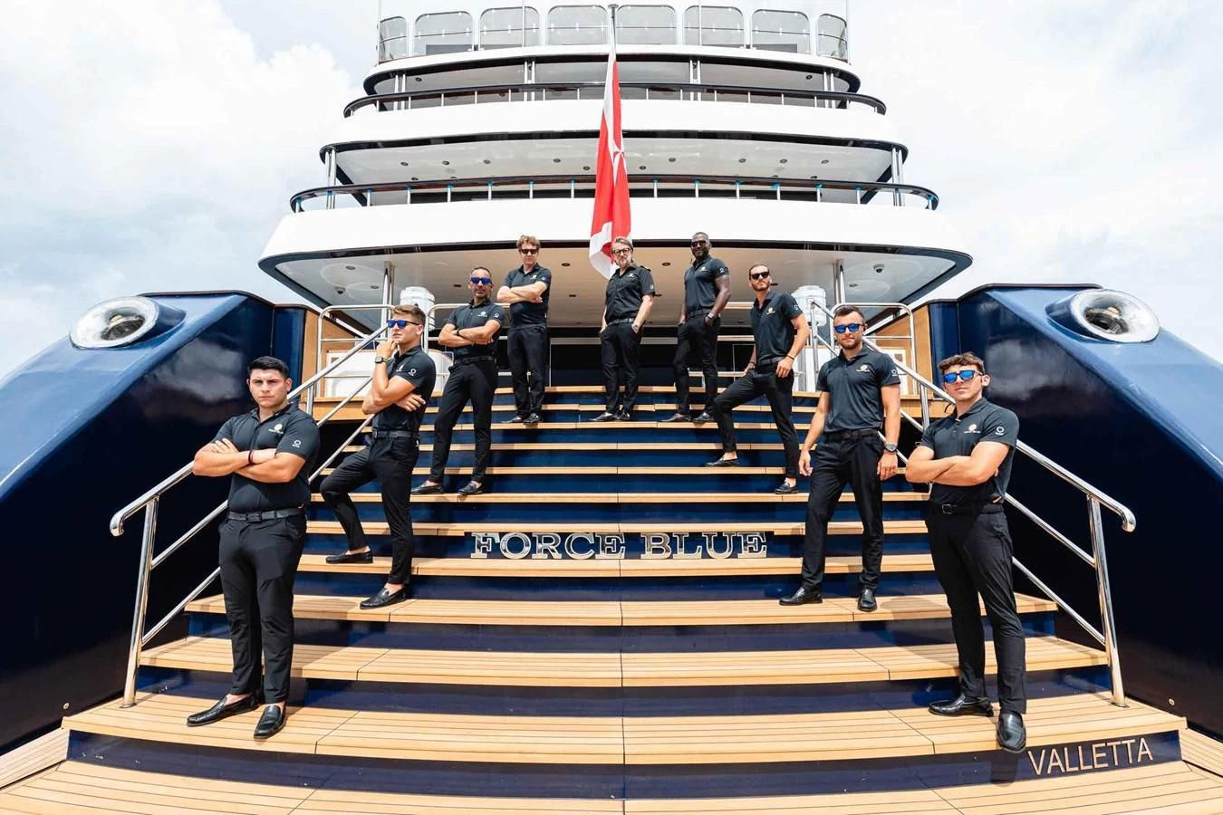 a group of people in uniform standing on a flight deck aboard FORCE BLUE Yacht for Charter