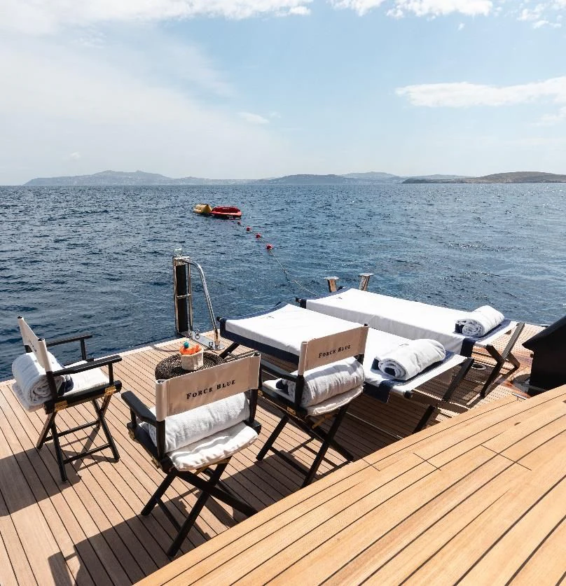 a deck with chairs and tables on it by the water aboard FORCE BLUE Yacht for Charter