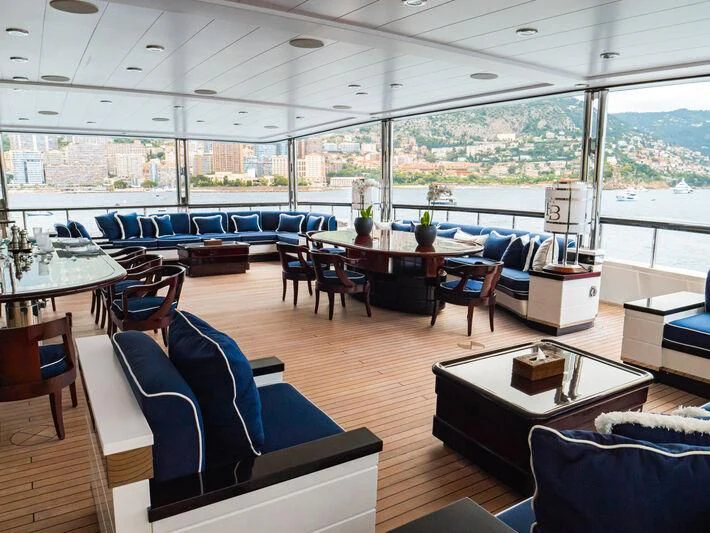 a room with a large window and a table with chairs and a large window with a view of aboard FORCE BLUE Yacht for Charter