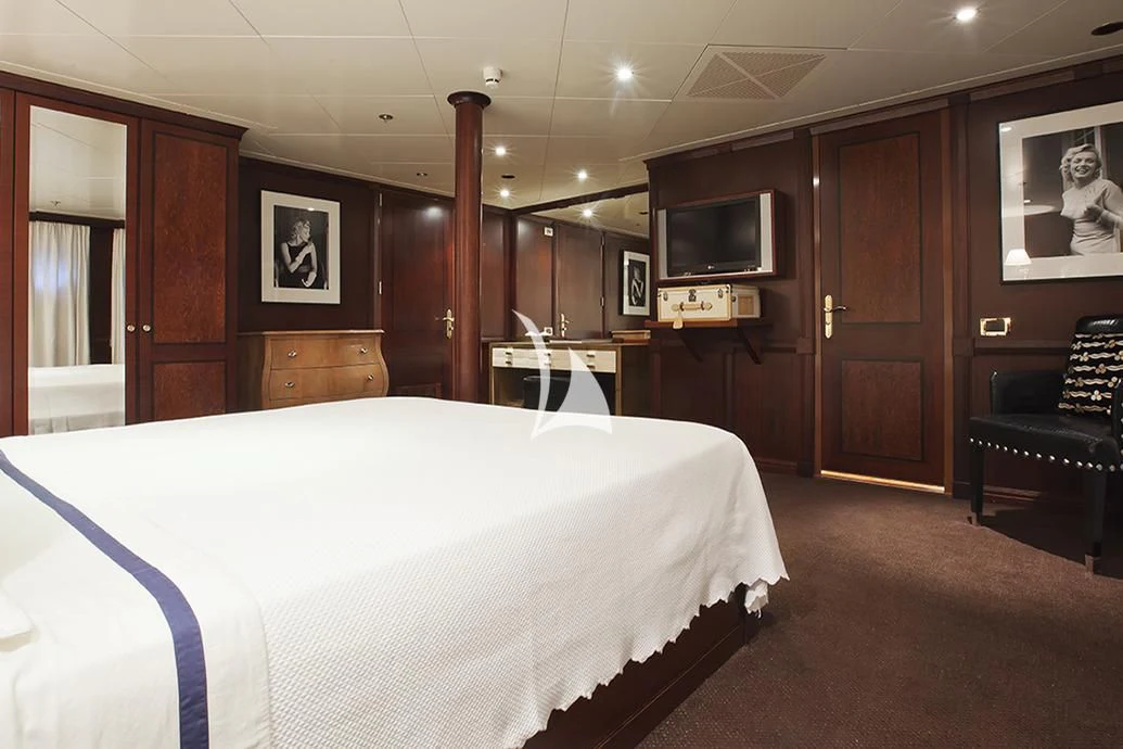 a bedroom with a bed and a chair aboard FORCE BLUE Yacht for Charter