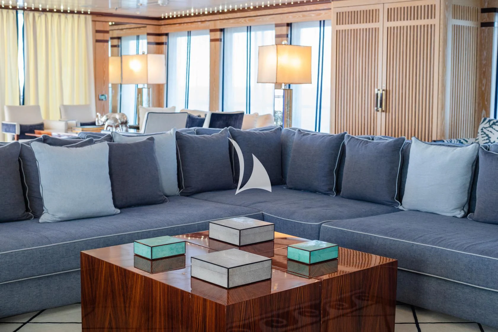 a couch with pillows and a coffee table in front of a window aboard FORCE BLUE Yacht for Charter