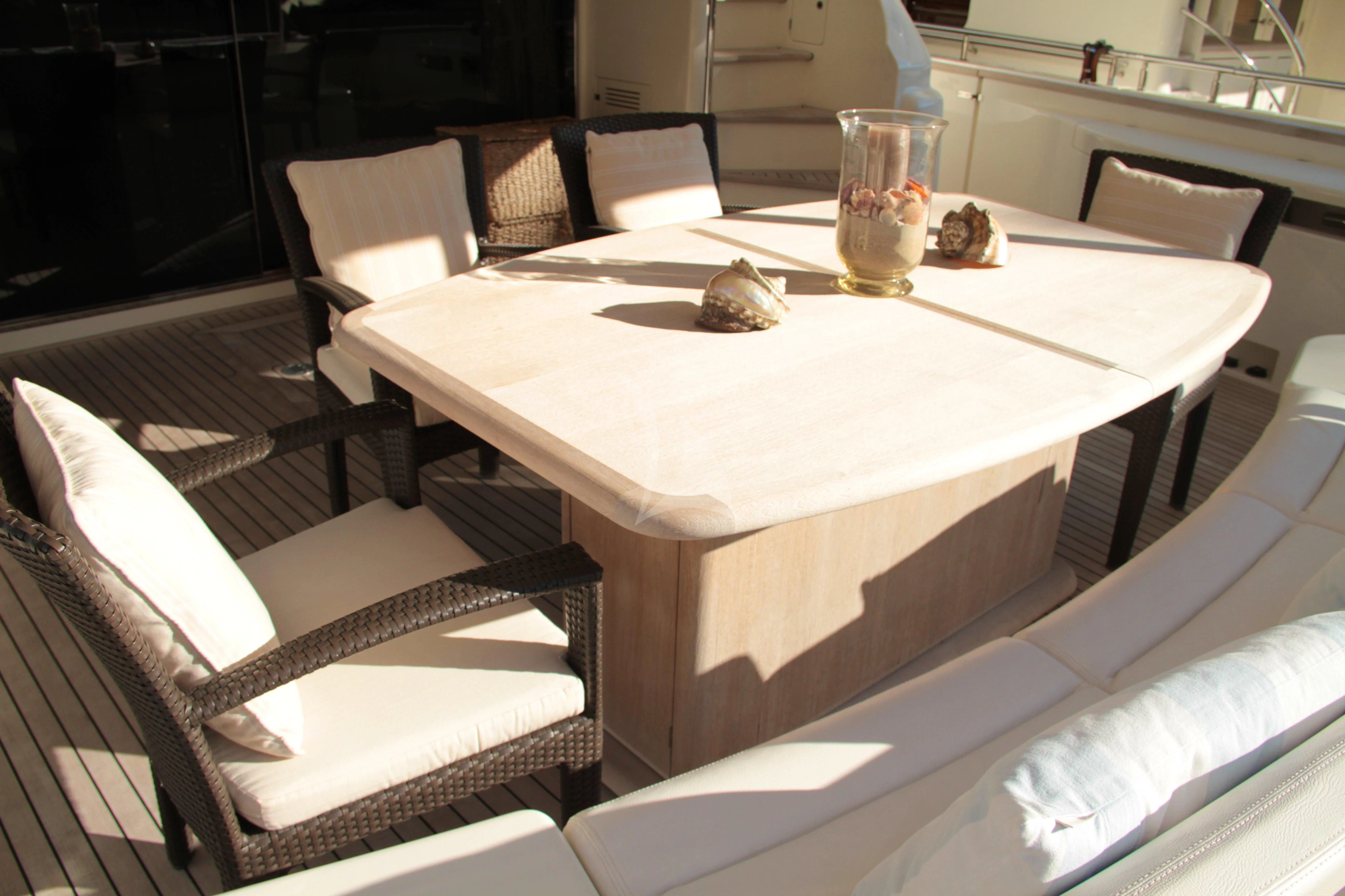 a table with chairs and a glass on it aboard EOLIA Yacht for Sale