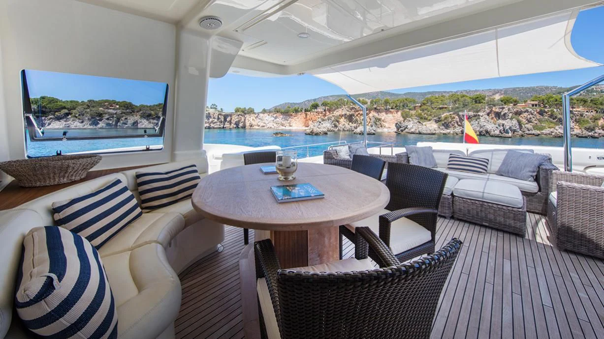 a room with a table chairs and a view of a city aboard EOLIA Yacht for Sale