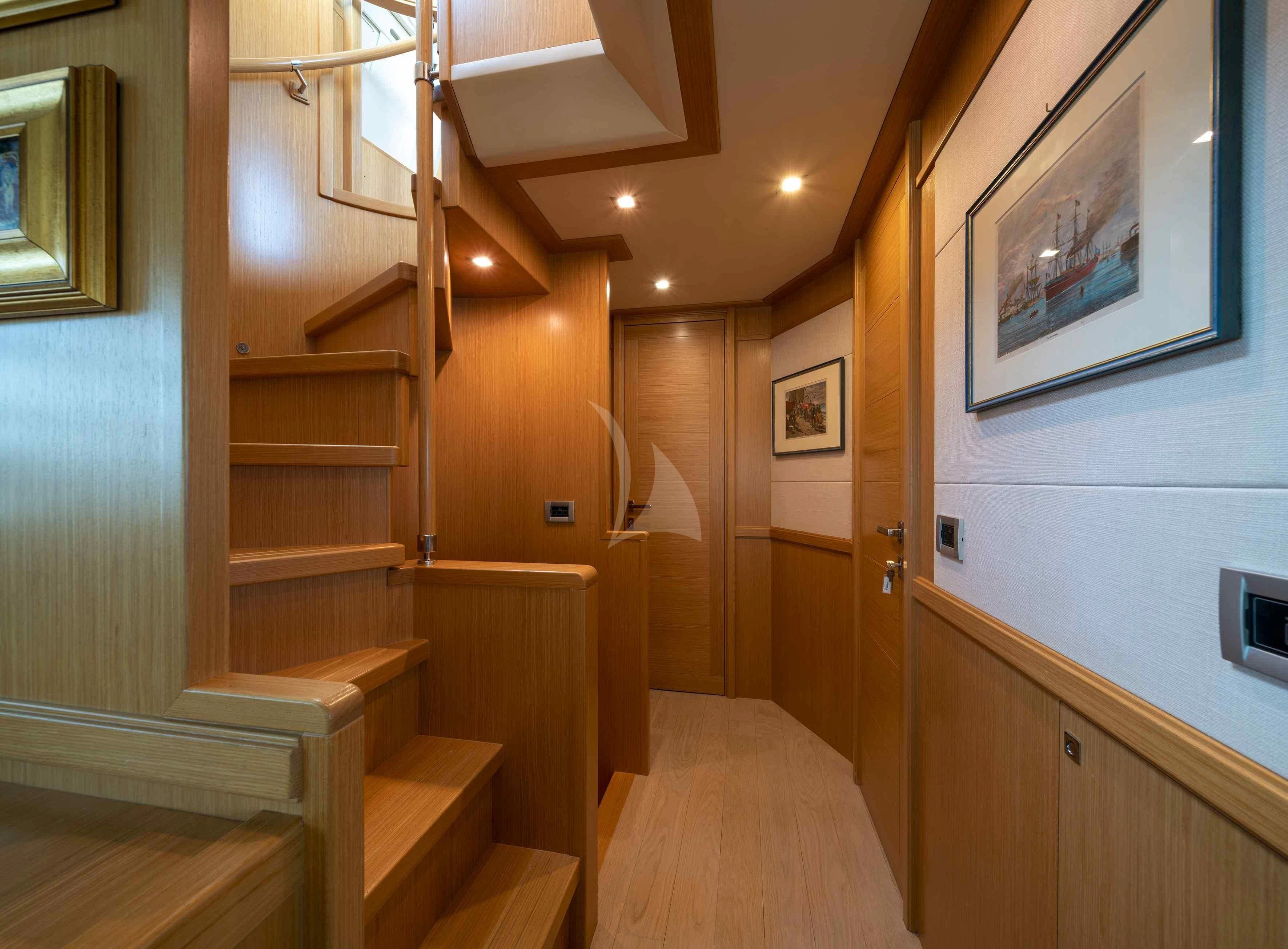 a wooden staircase with a wood railing aboard EOLIA Yacht for Sale
