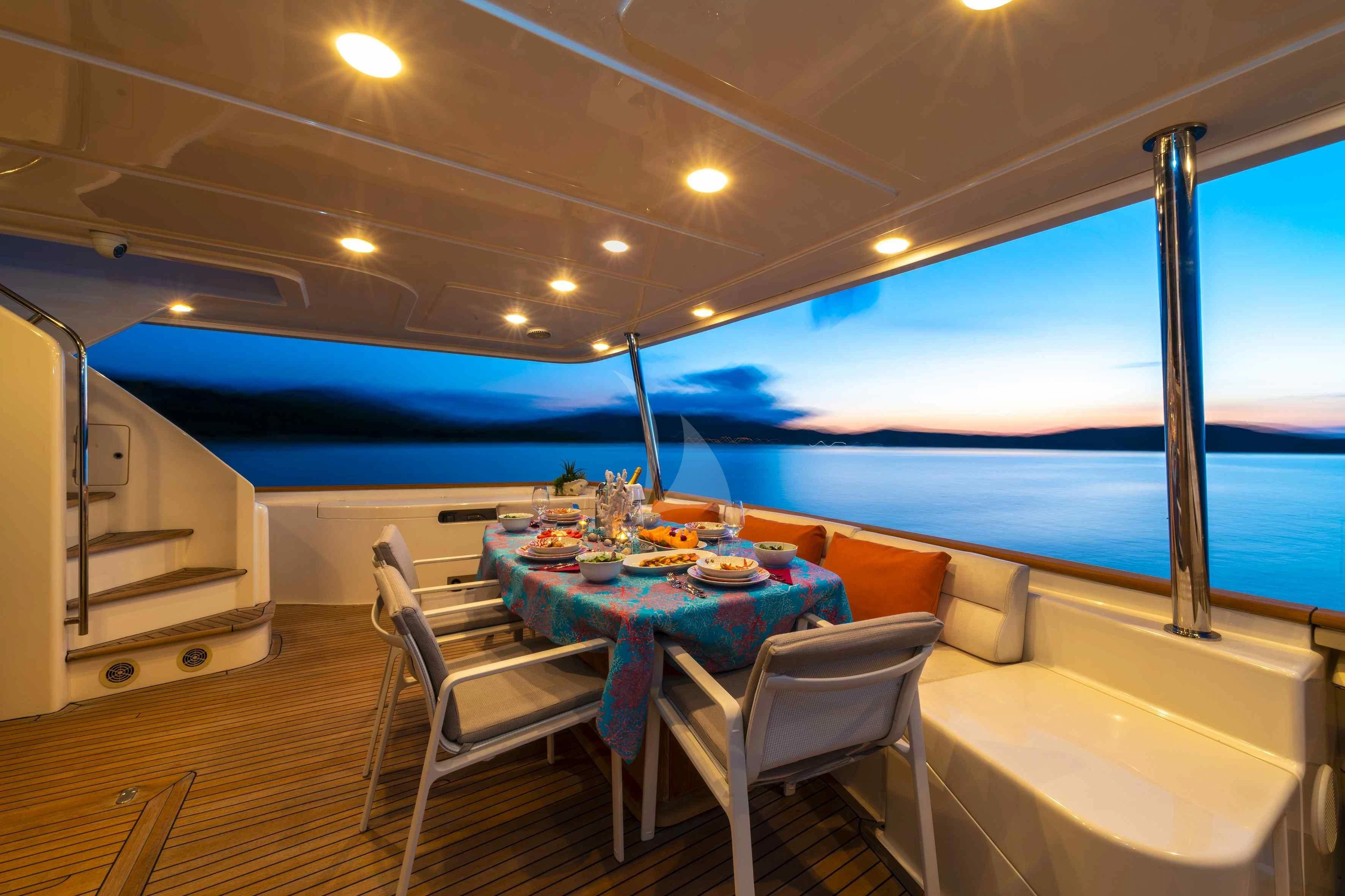 a table and chairs on a deck aboard EOLIA Yacht for Sale