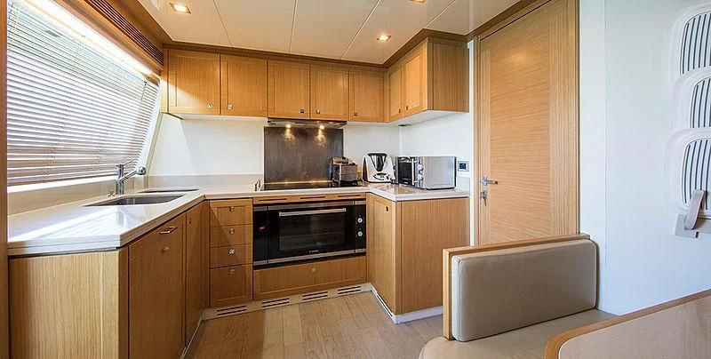a kitchen with wooden cabinets aboard EOLIA Yacht for Sale