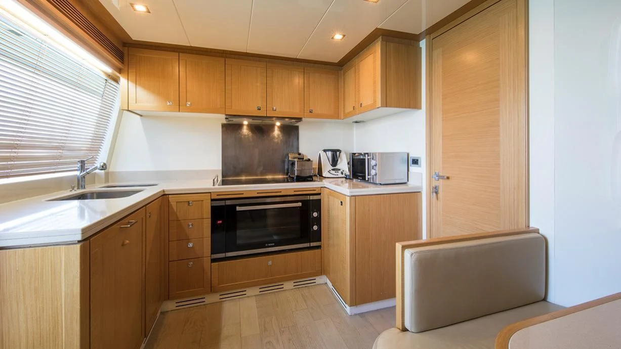 a kitchen with wooden cabinets aboard EOLIA Yacht for Sale