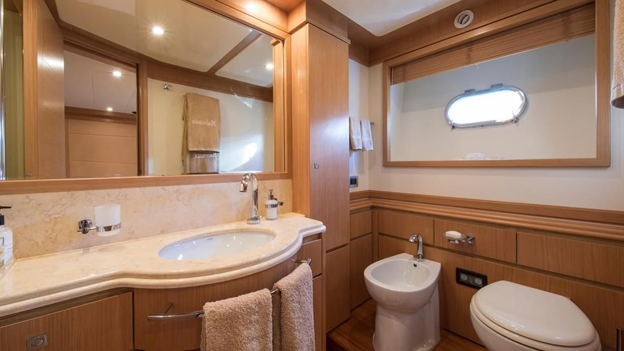 a bathroom with a sink toilet and a mirror aboard EOLIA Yacht for Sale