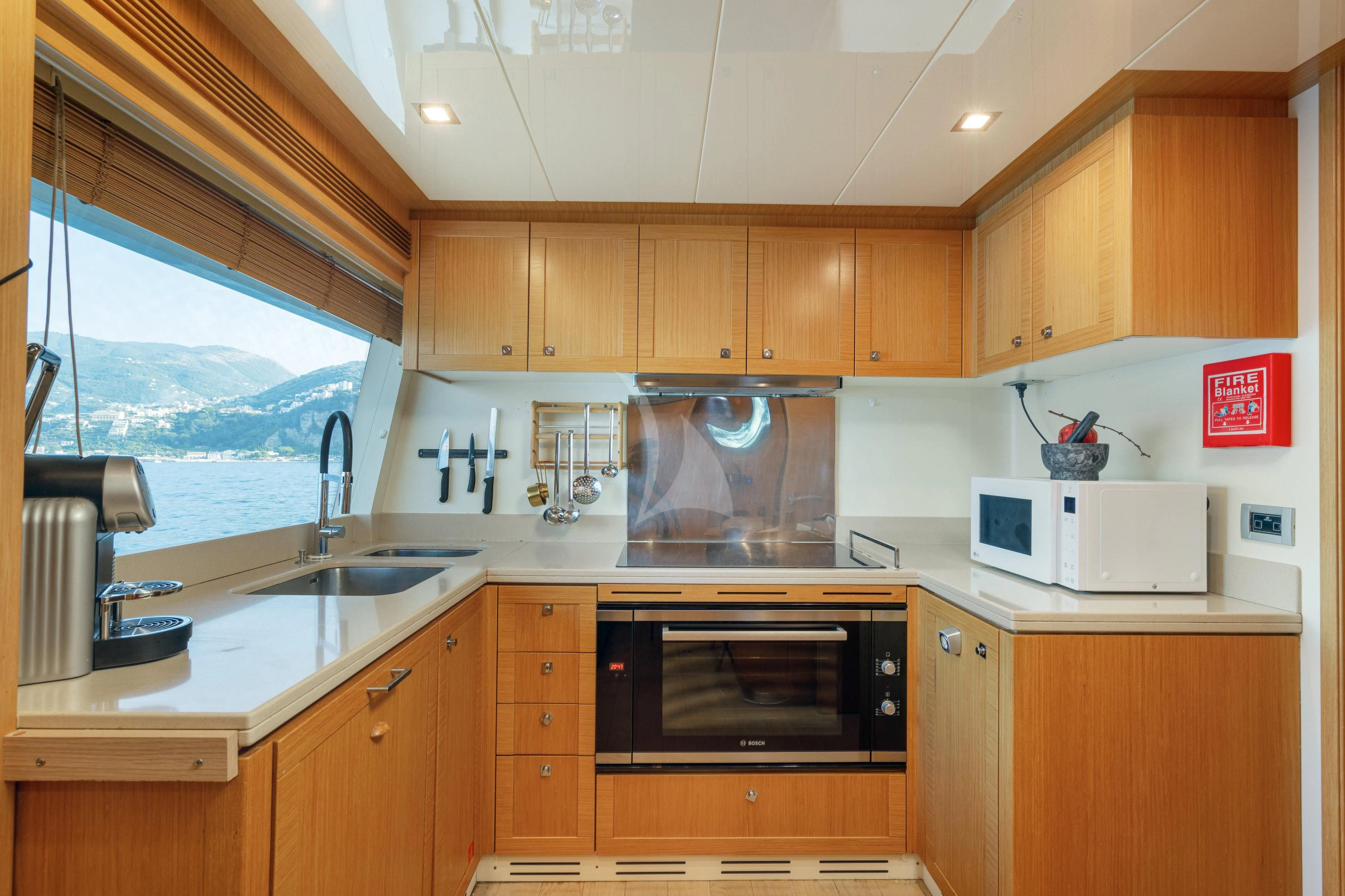 a kitchen with wooden cabinets aboard EOLIA Yacht for Sale