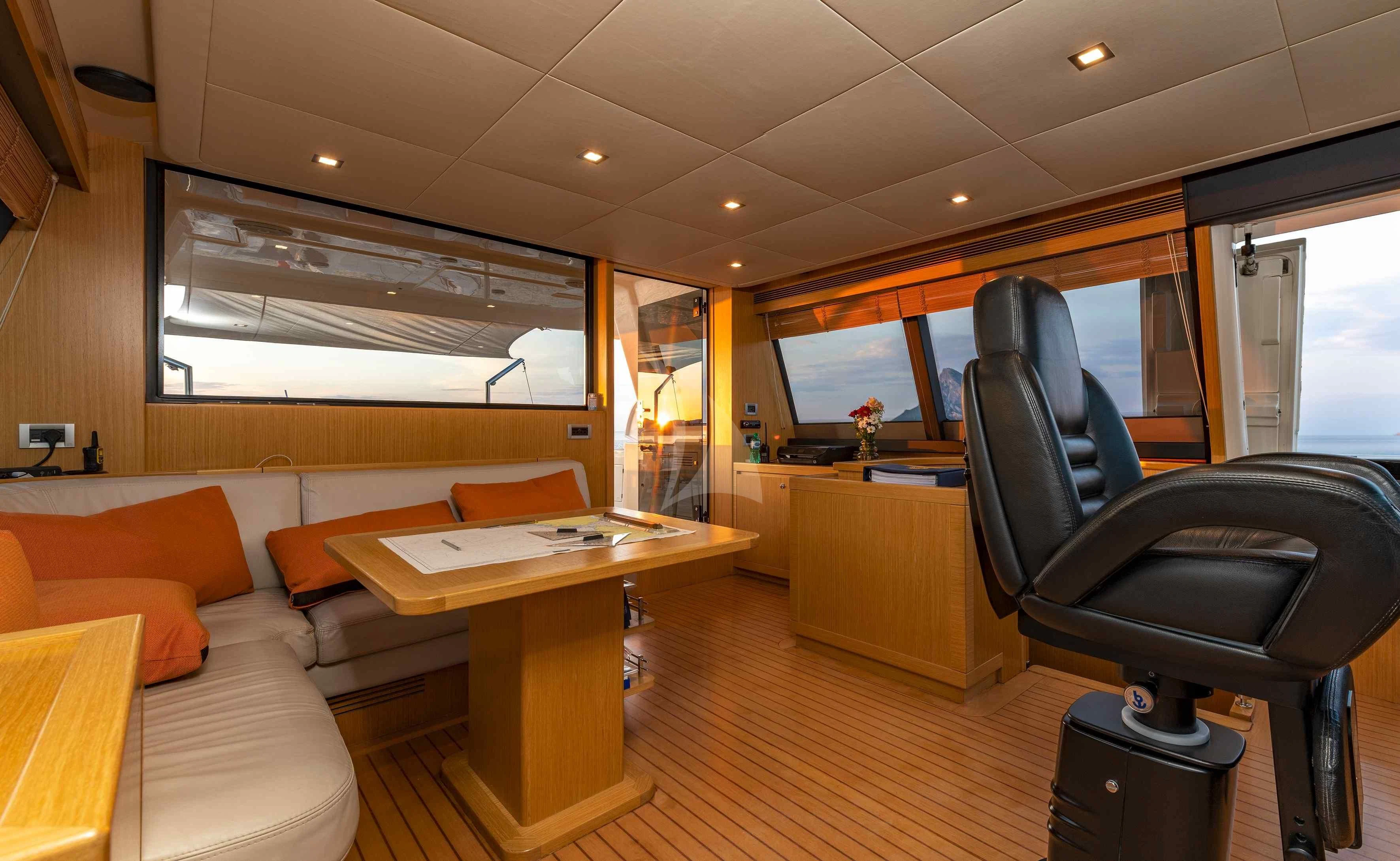 a room with a couch and a table and a chair aboard EOLIA Yacht for Sale