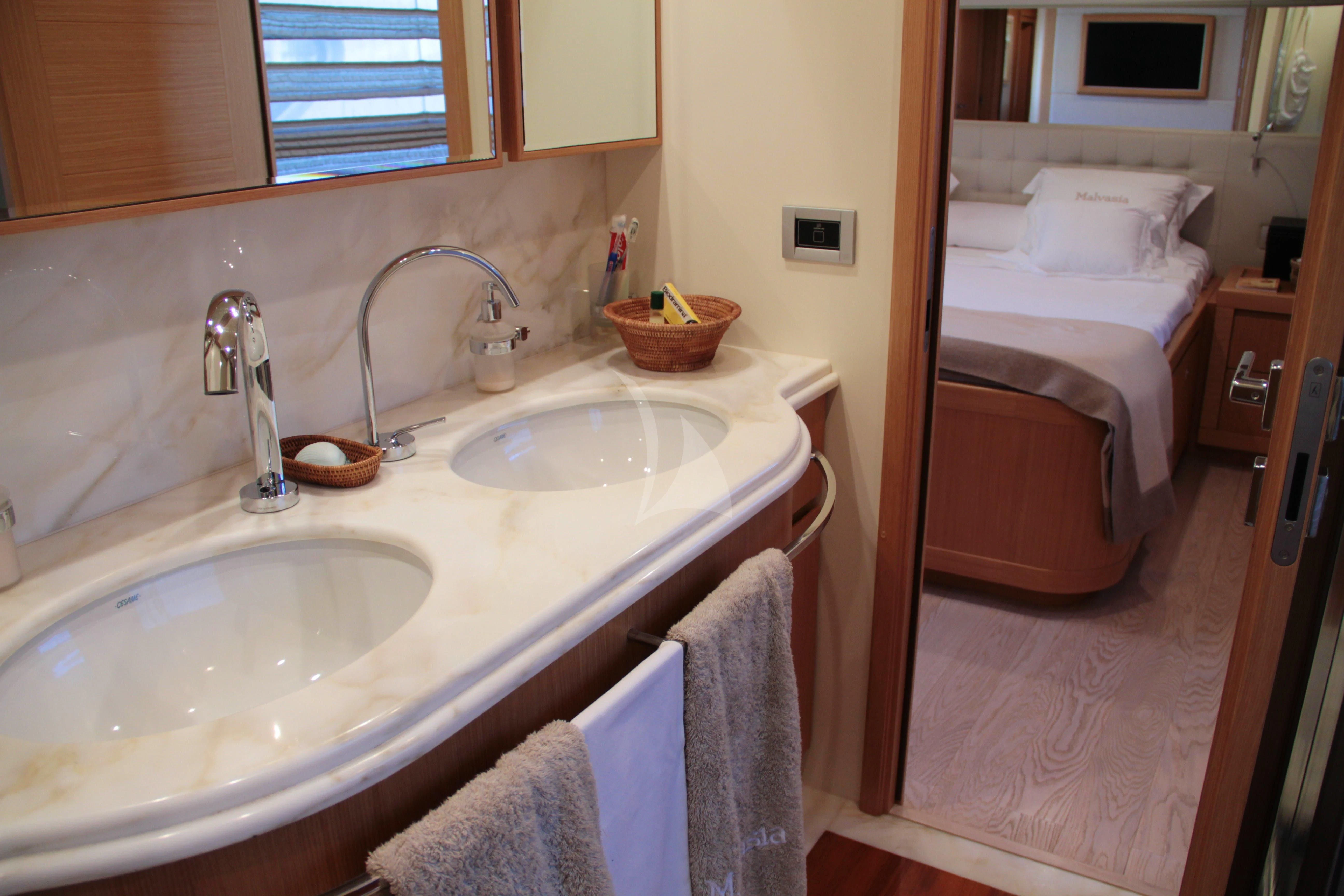 a bathroom with a sink and a bed aboard EOLIA Yacht for Sale