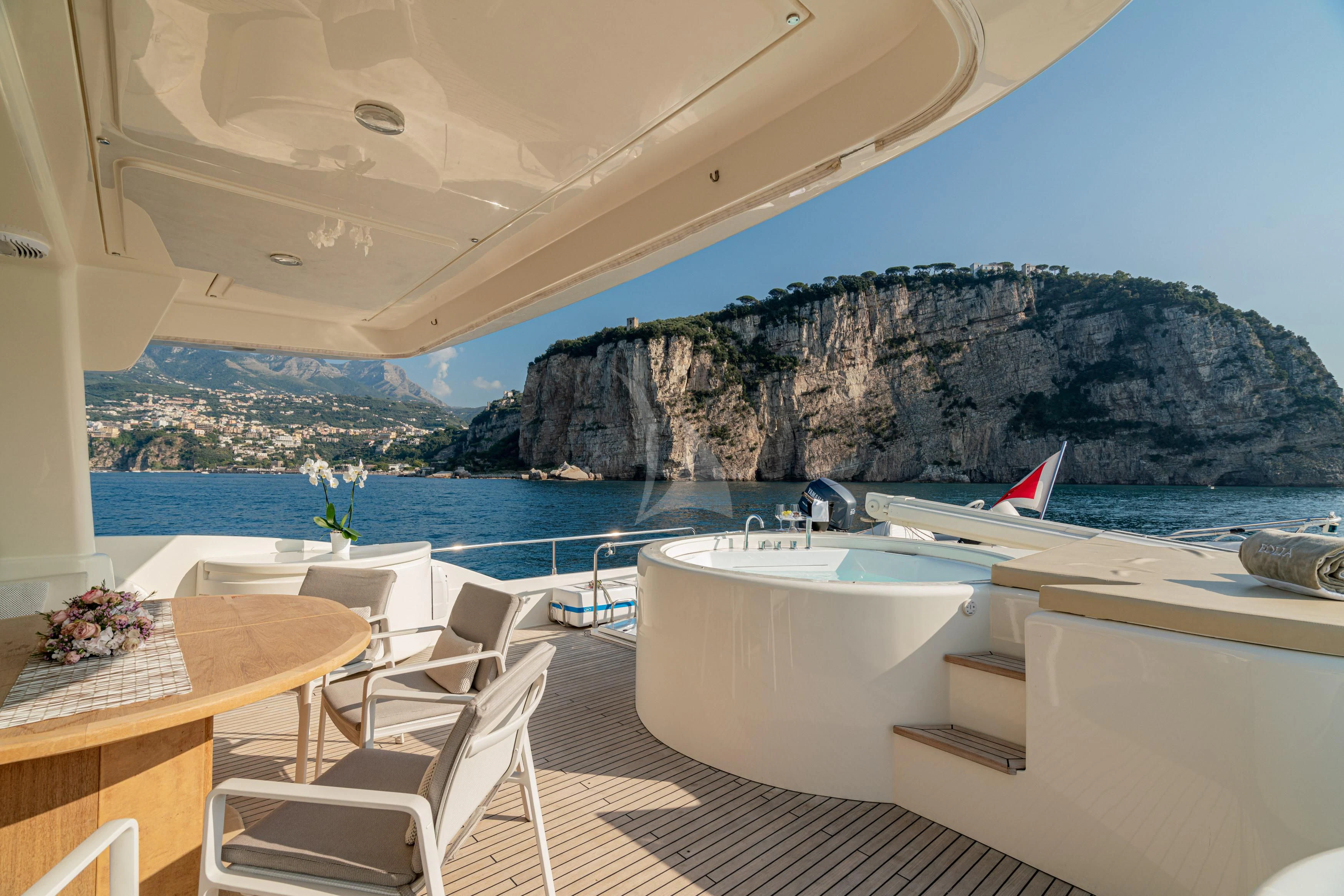 a room with a table chairs and a view of a body of water aboard EOLIA Yacht for Sale