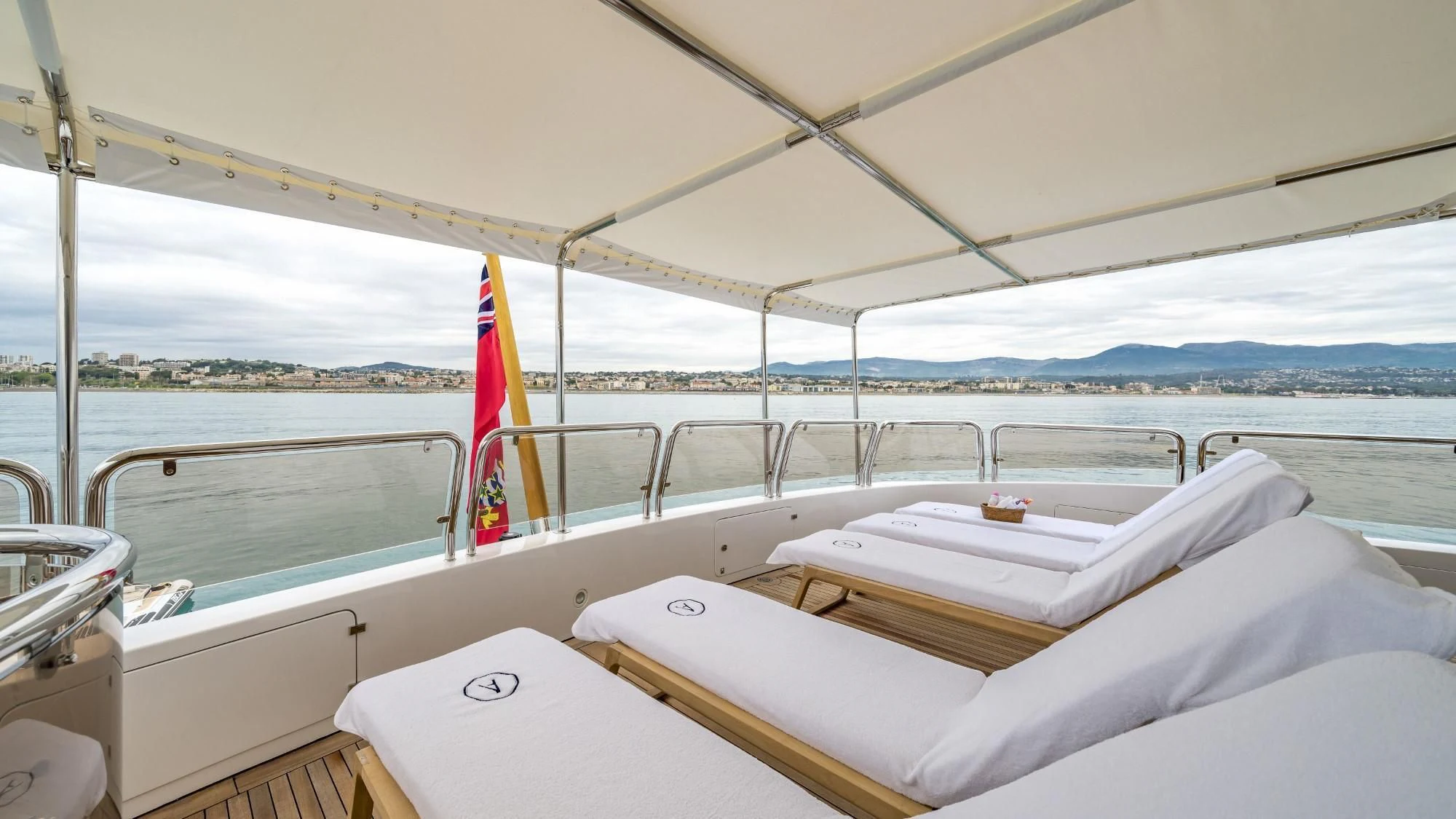 a boat with white sheets and a flag on the front aboard AURA Yacht for Sale