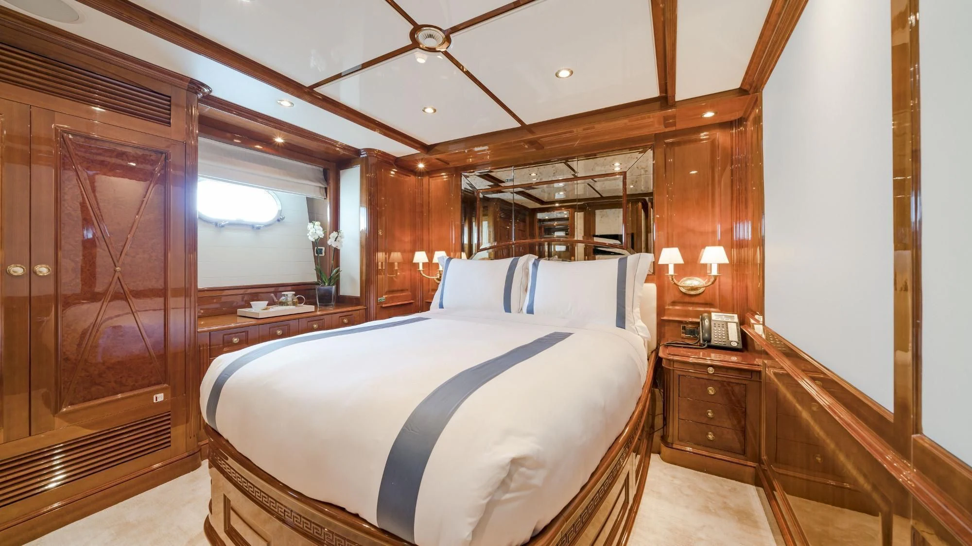 a bedroom with a bed and a wood door aboard AURA Yacht for Sale